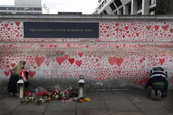 当地时间2021年4月7日，英国伦敦，泰晤士河旁议会大厦对面，民众在墙上画红心并留下鲜花，以祭奠英国死于新冠肺炎的病人。